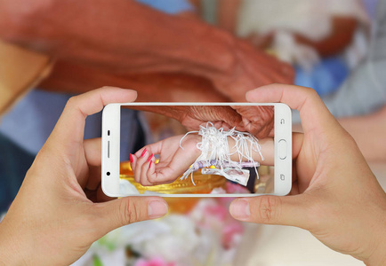 手在泰国礼仪与智能手机结合神圣的线程图片