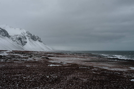 冰岛的粗糙海岸与一些山在背景