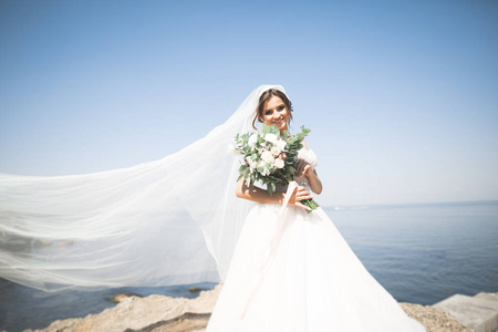 与新娘花束摆上背景大海美丽年轻的新娘