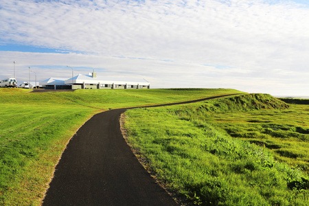景观与黑色沥青路穿过绿色的草地。Beuutiful 蓝天的背景。夏天风景风景