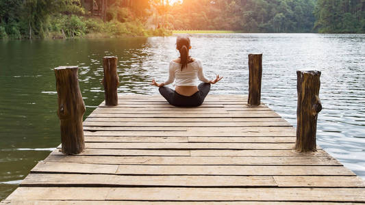在自然, 健身, 放松, 生活方式的桥梁上练习瑜伽的年轻健康妇女