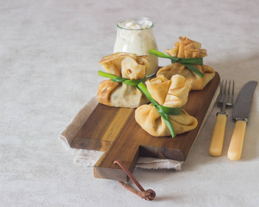 在木制的切板上塞满鸡肉和蘑菇的薄饼 煎饼, 配上酸奶油。煎饼周的传统食物。斯拉夫菜传统菜