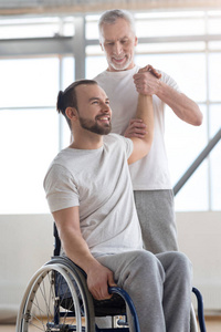 熟练的骨科医生与残疾人在健身房锻炼