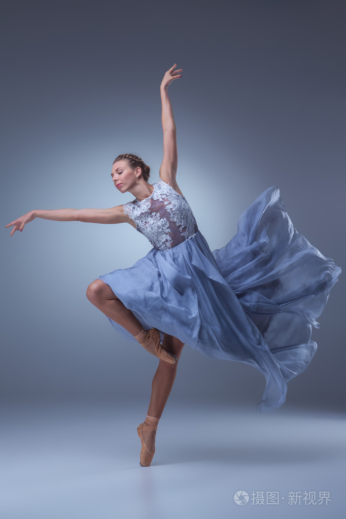 美丽的芭蕾舞演员在蓝色长裙跳舞