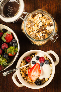 健康早餐与麦片, 浆果和酸奶在木桌上