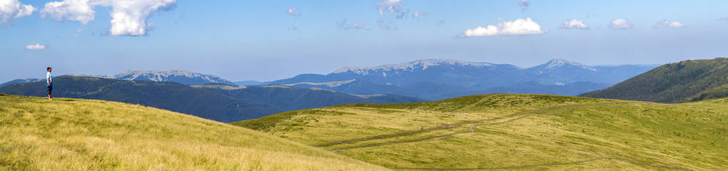 孤独的徒步旅行者站在宽阔的山坡上 enjoing 山景