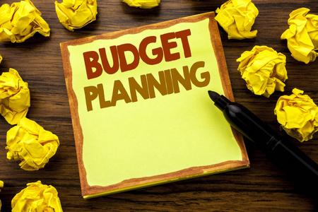 手写显示预算计划的文本标题。财务预算编制的商业概念粘纸条纸, 木质背景与标记折叠黄色纸意义思维