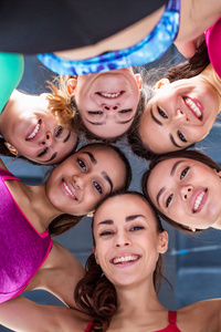 体育友谊。六美丽的微笑运动的妇女趴在地板上的头在健身房和有趣的看着相机