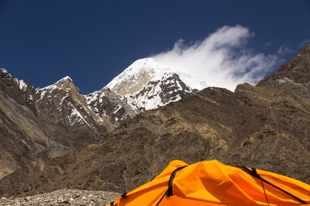 高山峰和裁剪的橙色帐篷