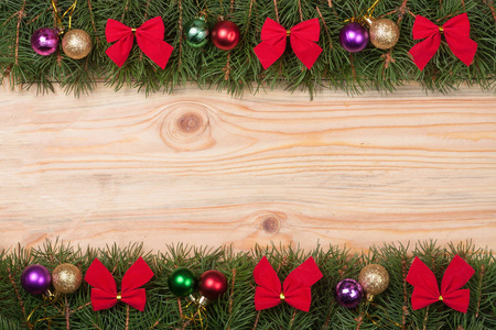 圣诞框架作出了冷杉的枝条装饰着红色的弓和轻木背景上的球