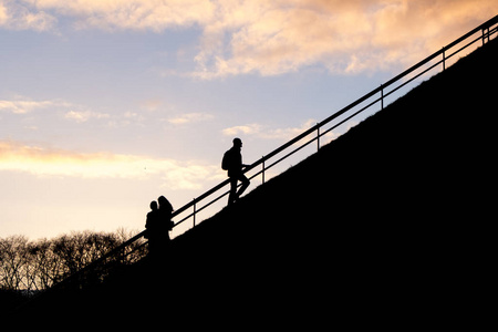 人的剪影在日落天空背景攀登方式或台阶