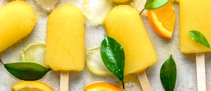 橙冰棒与果汁冰在棍子上, 自然清爽的冰淇淋甜点夏天