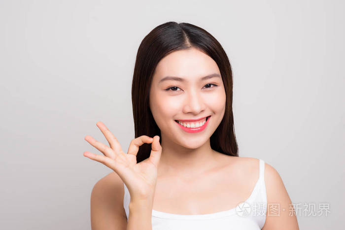 美丽的年轻女人的肖像与干净的皮肤手势 ok 标志