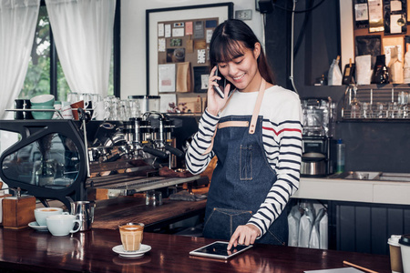女咖啡师以手机和平板电脑订购, 亚洲女性 waitre