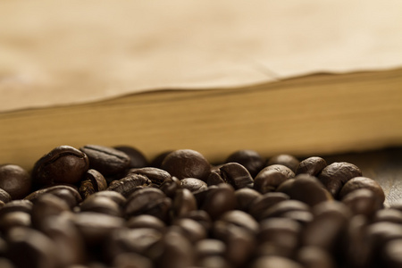 烘培的咖啡豆上陈年打开的书。菜单，食谱，模拟了。木制的背景