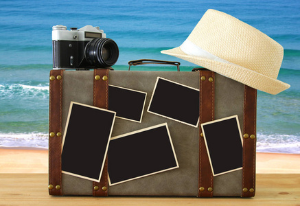 老式的行李, 软呢帽帽子, 老式旧照片相机和空白照片的图片蒙太奇样机在木地板上的形象