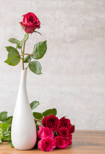 白色花瓶和大理石背景的红玫瑰