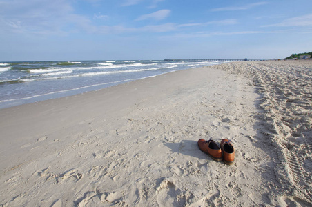 假日概念由商人鞋子在海滩被留下了反射