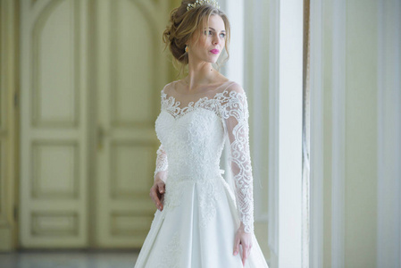 美丽的新娘在婚礼礼服白色内部
