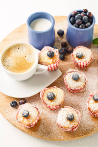 早餐咖啡与迷你松饼和蓝莓在一个木制的立场