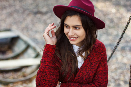 可爱的女孩在红色的羊毛衫和秋天的帽子