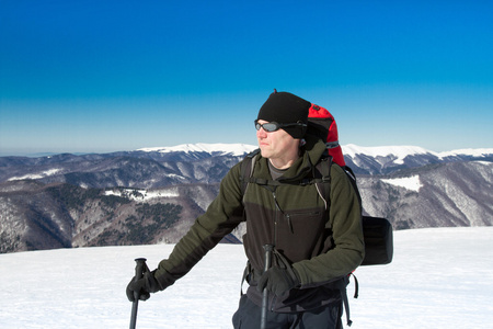 在山里徒步旅行带着背包和帐篷雪的冬天