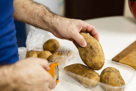 手持新鲜土豆的人的手有选择性聚焦