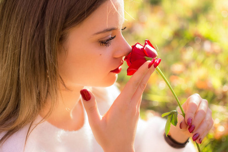 女孩在圣情人节嗅到一朵红玫瑰