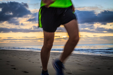 日出时在沙滩上奔跑的人腿