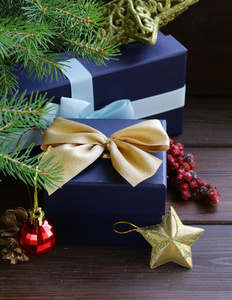 礼品盒用节日彩带和圣诞装饰品木制背景上