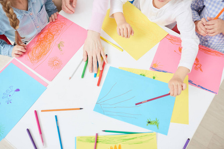 彩色纸, 蜡笔和人的手在画的图片讨论的顶部视图