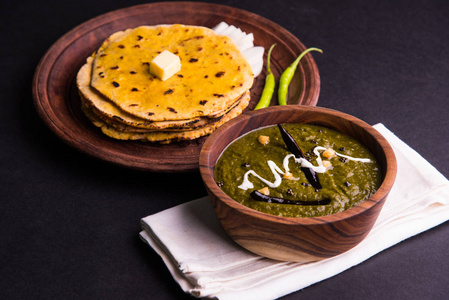 玉米面粉扁平的面包或烤肉或 Makki Ki Roti 与 sarso da Saag 或芥菜叶咖喱，印度的食物在流行冬季在北印