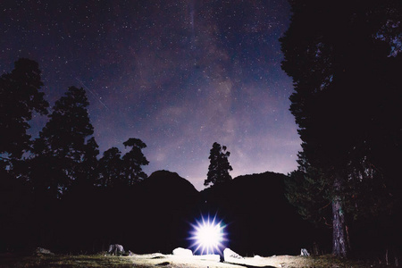 银河, 树木和人的剪影在山上的光。夜风景