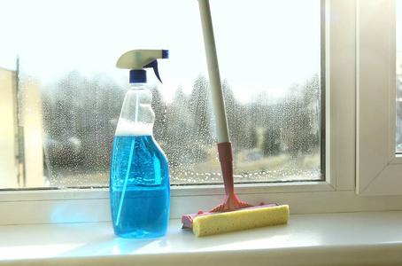 玻璃刮刀和窗清洁瓶。用刮刀清洁窗户