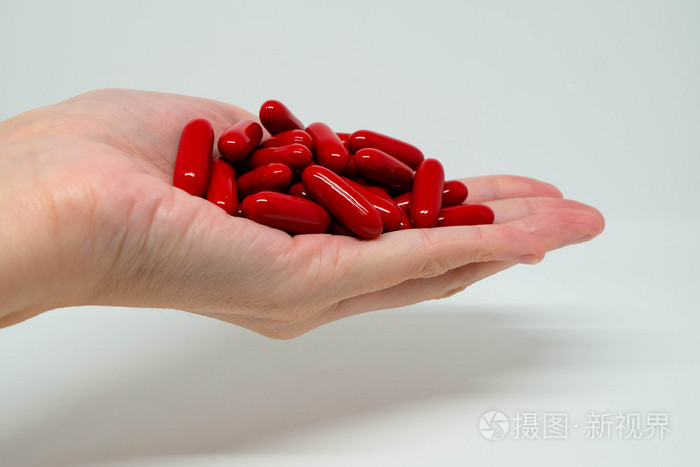红色的维生素胶囊一方面棕榈