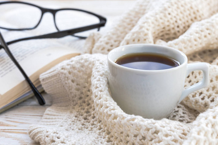 温暖的针织的格子，眼镜，杯热咖啡和书