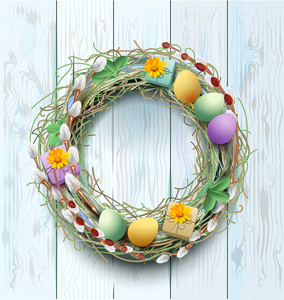 复活节花圈装饰。蓝木背景和彩色鸡蛋的分支