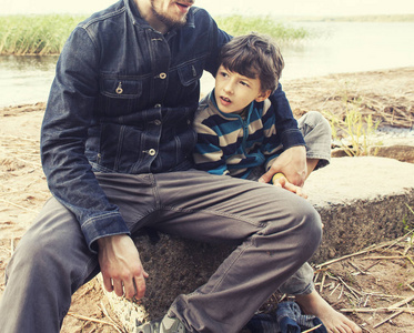 年轻的父亲与胡子和他的小儿子在湖上的时髦