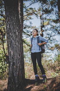 年轻的徒步旅行的妇女在徒步旅行到山上休息。冒险假日概念