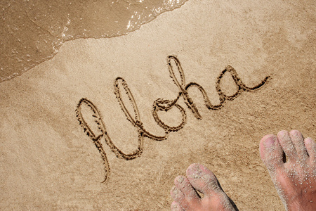 在沙滩上手写的概念或概念的aloha文本