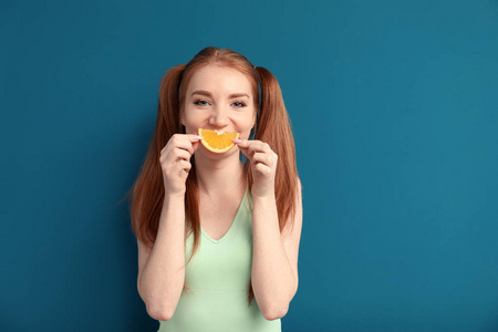 有趣的年轻妇女与切片的柑橘水果的颜色背景