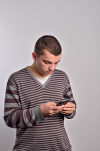 年轻人看他的智能手机同时发送文本消息