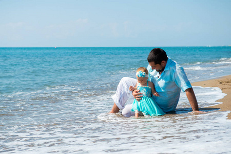 快乐的父亲和他可爱的小女儿在海滩上