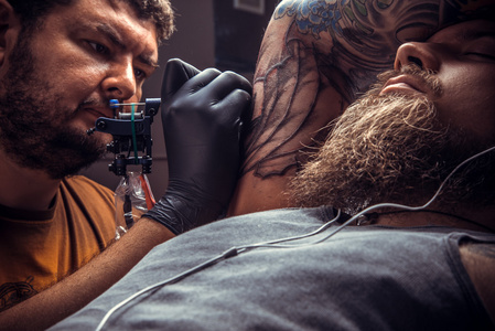 专业的 tattooer 使纹身图片在沙龙