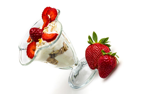 牛奶什锦早餐与草莓和酸奶上白色孤立的玻璃
