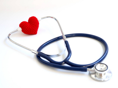 红色心脏使用听诊器在白色背景 隔绝的背景。爱的概念和关爱病人的心。复制文本和内容的空间