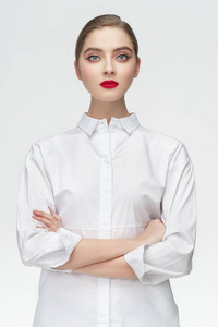 工作室肖像的商业女孩在白色衬衫上的灰色隔离背景。概念 严肃的女孩经理或学生