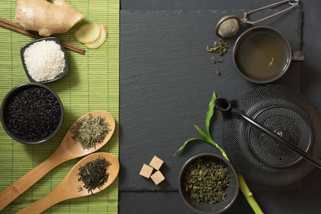 青日本茶用传统食物集在黑石桌上。具有复制空间的顶部视图