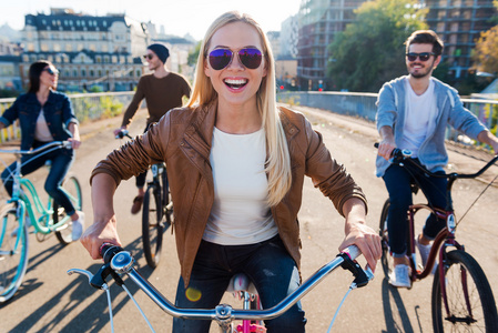 微笑的女人骑自行车和朋友