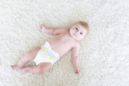 刚出生的婴儿用纸尿裤的女孩。干性皮肤和苗圃